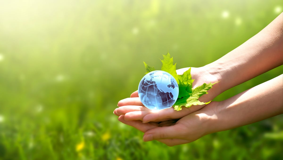 Environment Day concept. Earth globe in human hand on grass background. Saving environment, save clean green planet, ecology theme. Card for World Earth Day.